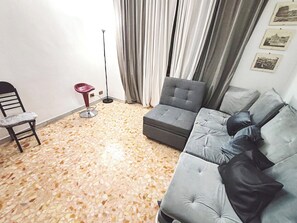 Un soggiorno con un divano, una poltrona e una lampada da terra.