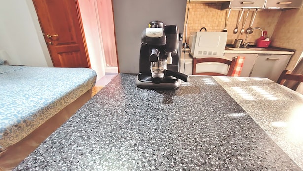 A kitchen with a coffee maker on a granite countertop. - Apartment in the heart  of Rome free fast  wi fi (Roma)