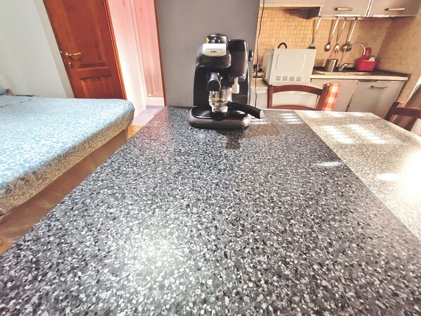 A kitchen with a coffee maker on a granite countertop. - Apartment in the heart  of Rome free fast  wi fi (Roma)