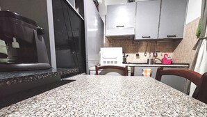 Una cocina con encimeras de granito, armarios blancos y una campana extractora de acero inoxidable.
