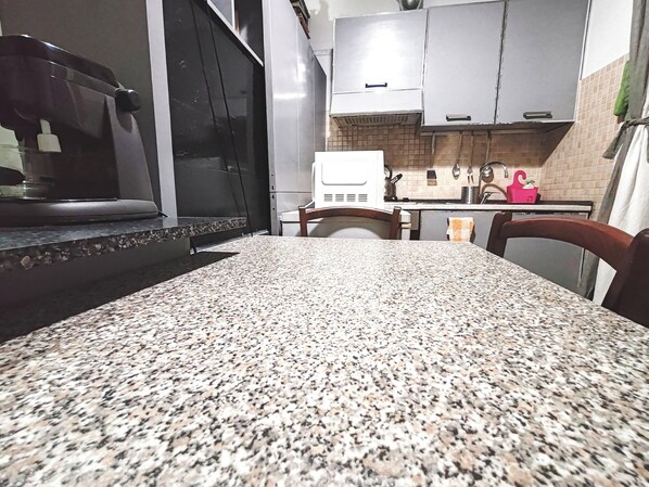 A kitchen with granite countertops, white cabinets, and a stainless steel range hood. - Apartment in the heart  of Rome free fast  wi fi (Roma)