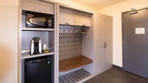 A compact kitchen with a microwave, coffee maker, and a small refrigerator. - Holiday Inn Kalamazoo West by IHG (Kalamazoo)