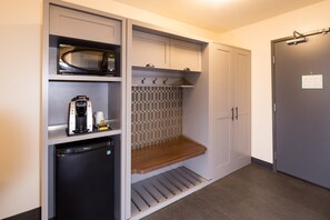 A compact kitchen with a microwave, coffee maker, and a small refrigerator. - Holiday Inn Kalamazoo West by IHG (Kalamazoo)