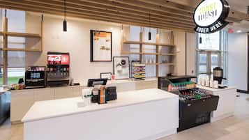 Una barra de desayuno moderna con un menú a la vista, una máquina de café y un dispensador de bebidas.