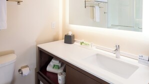 A modern bathroom with a white sink, a large mirror, and a towel rack. - Holiday Inn Kalamazoo West by IHG (Kalamazoo)