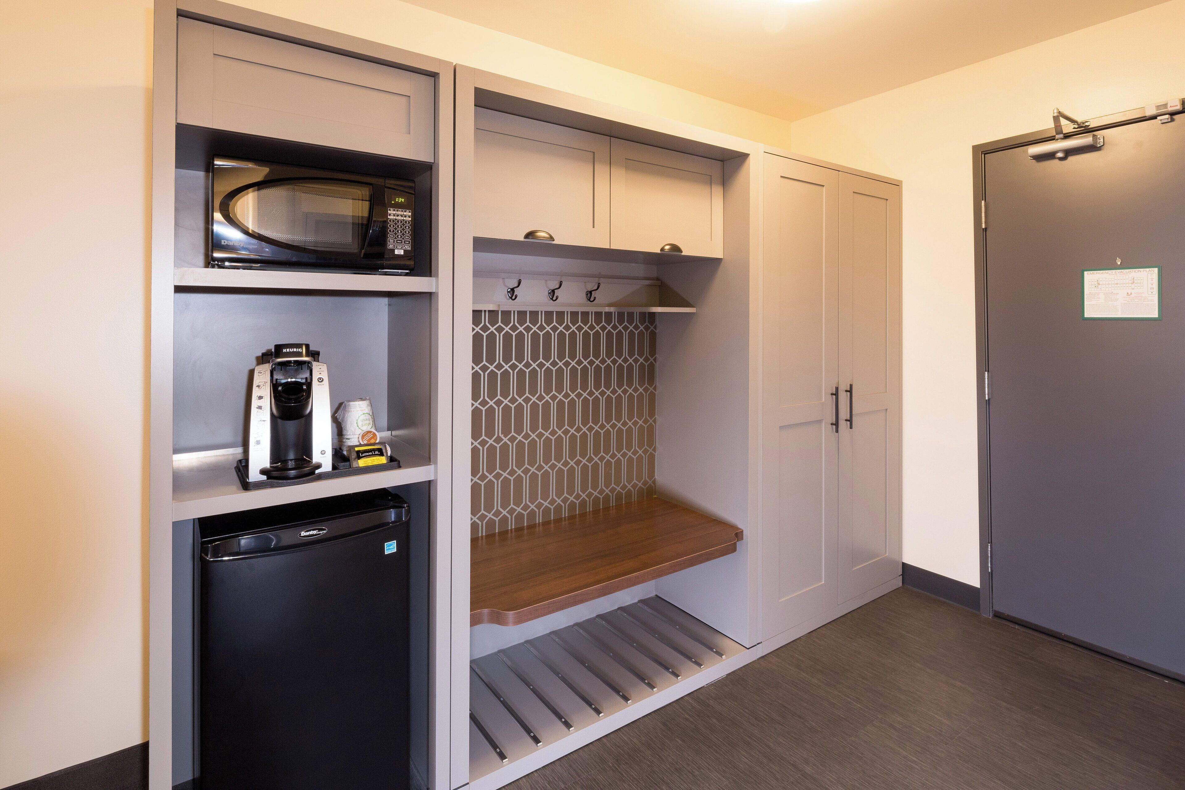 A compact kitchenette with a microwave, coffee maker, and a small refrigerator.