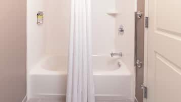A bathroom with a bathtub, a shower curtain, and a toilet.