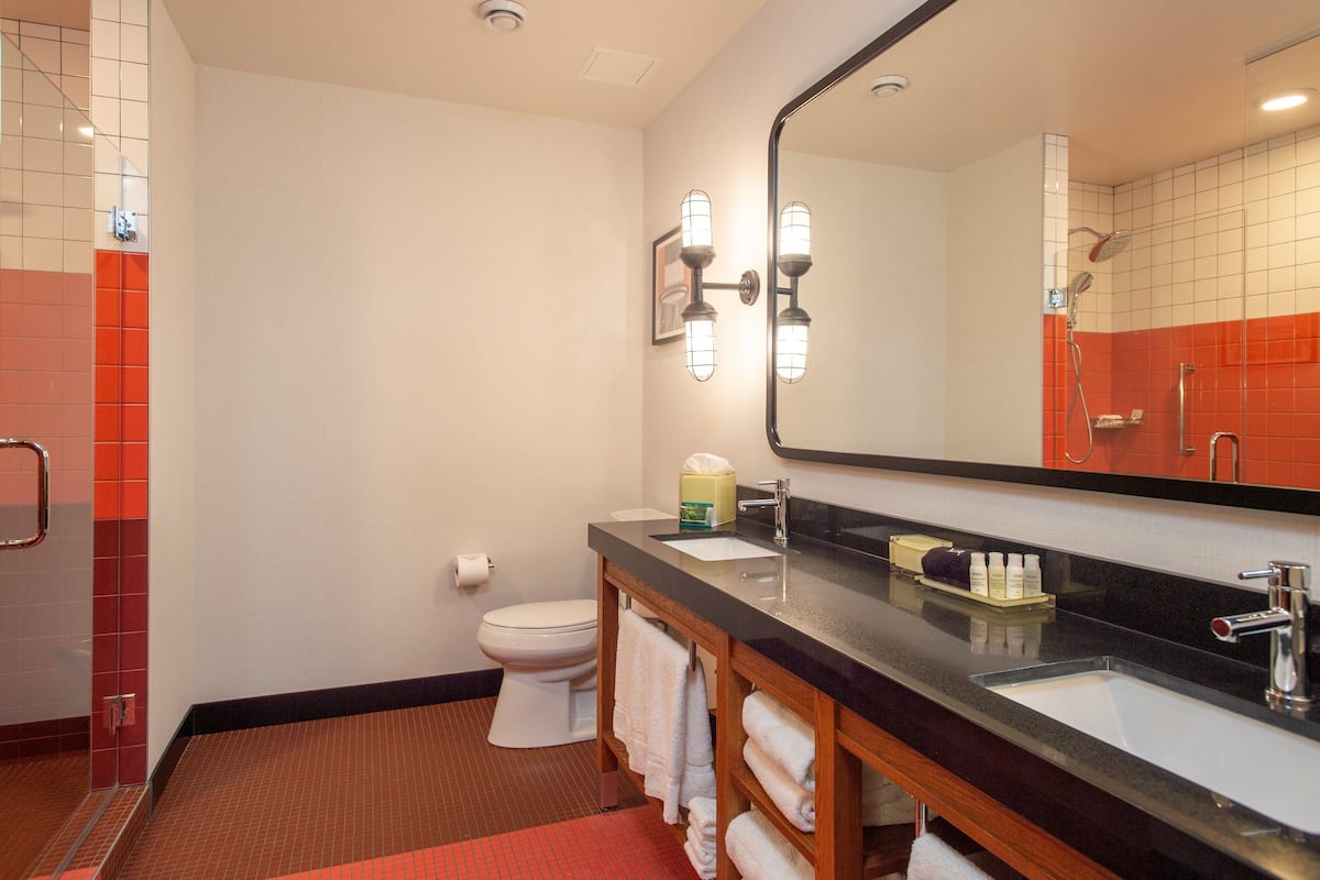 suite, 1 king bed, roll-in shower (communications) | bathroom | shower, rainfall showerhead, designer toiletries, hair dryer