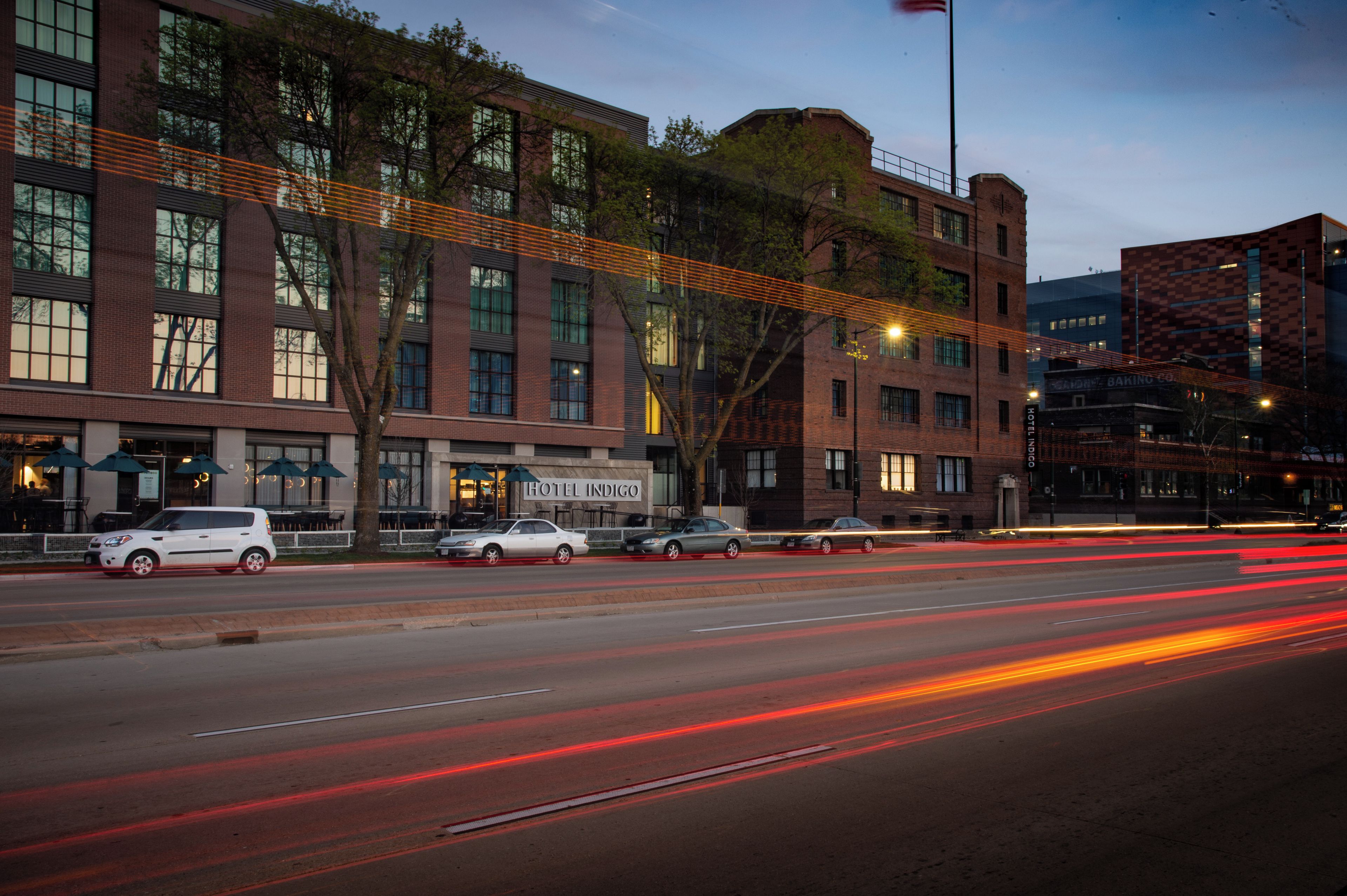 A hotel with a brick facade, multiple windows, and a sign for 'HOTEL INDIGO'.
