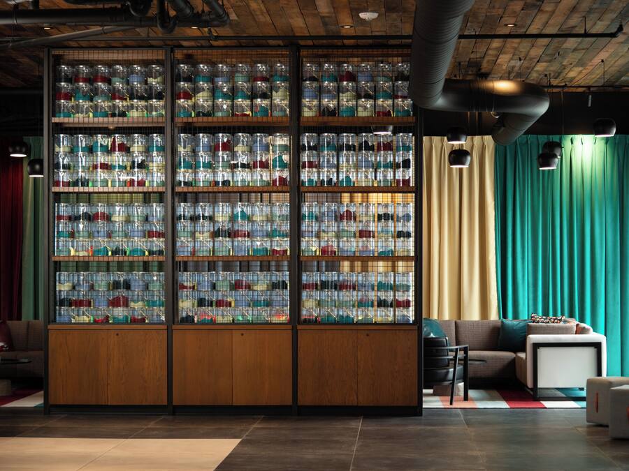 A room with a large display of colorful items in glass containers, a sofa, and a coffee table.
