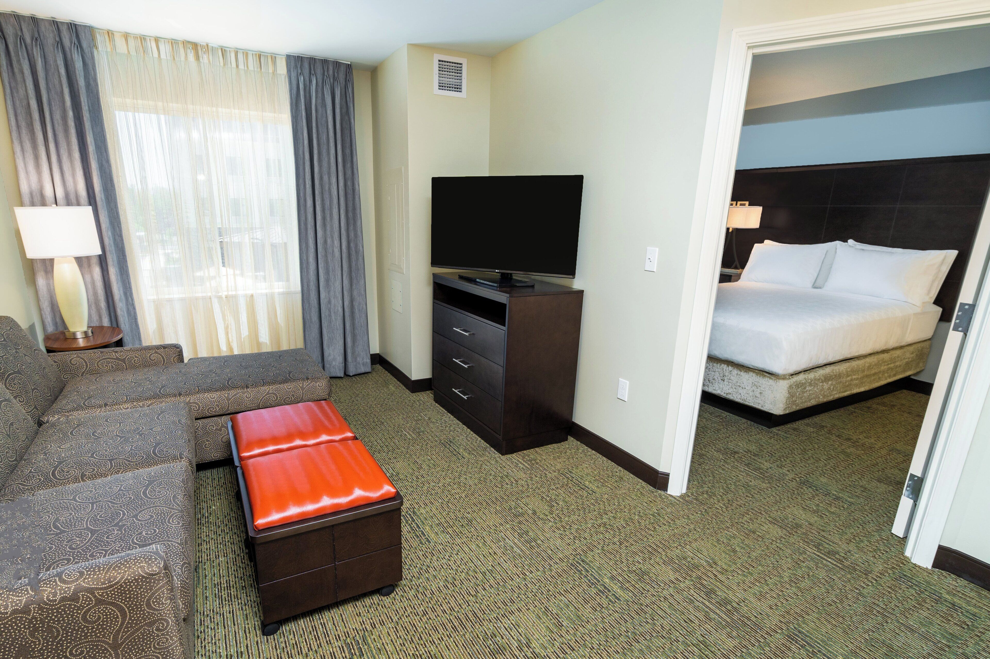 Une chambre d’hôtel avec un canapé, une télévision, un bureau et un lit.