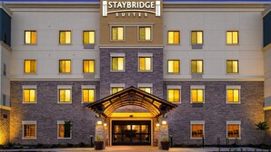 A Staybridge Suites hotel with a modern facade, multiple windows, and a prominent entrance with a covered walkway. - Staybridge Suites Newark - Fremont by IHG (Newark)