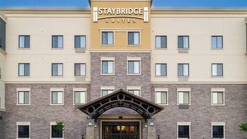 A Staybridge Suites hotel with a modern facade, multiple windows, and a prominent entrance.