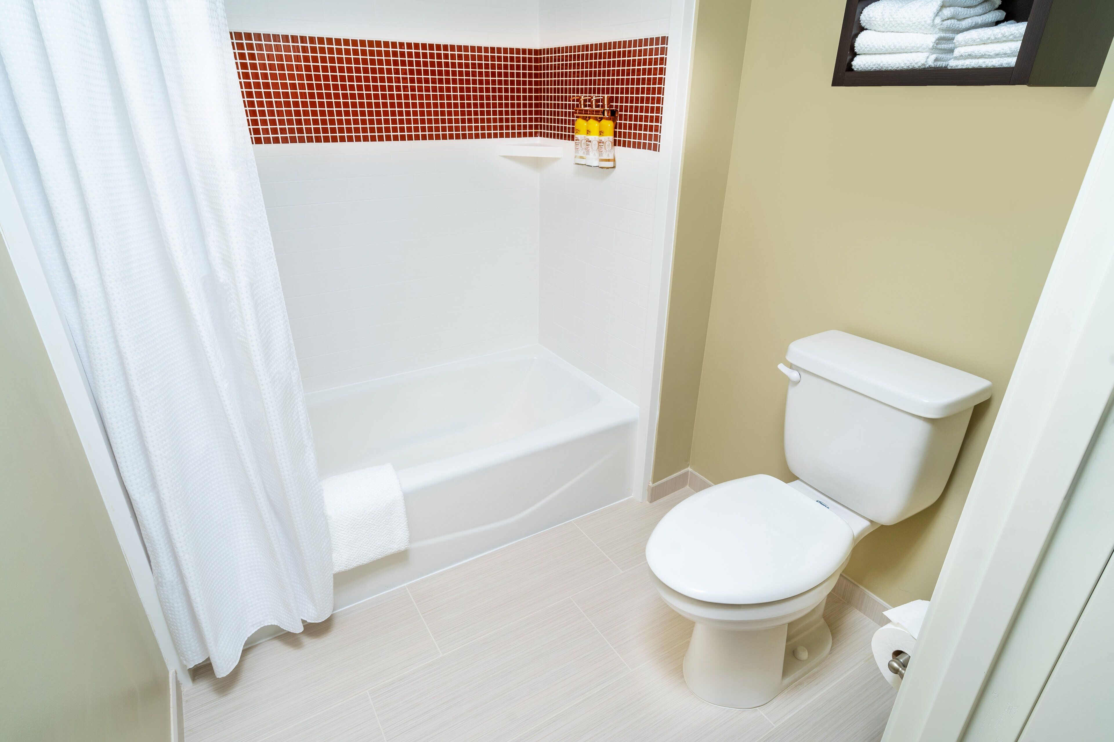 A bathroom with a white bathtub, a white toilet, and a shower curtain.