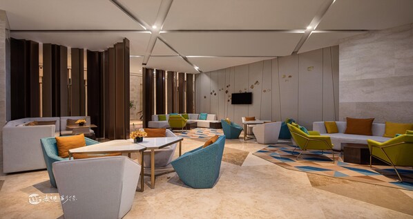 A modern lounge area with sofas, chairs, and tables. - Holiday Inn Hotel & Suites Langfang New Chaoyang by IHG (Langfang)