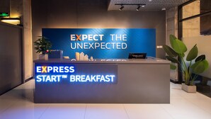 A reception desk with a sign that reads 'EXPRESS START™ BREAKFAST' and 'EXPECT THE UNEXPECTED.' - Holiday Inn Express Beijing Shijingshan Parkview by IHG (Beijing)