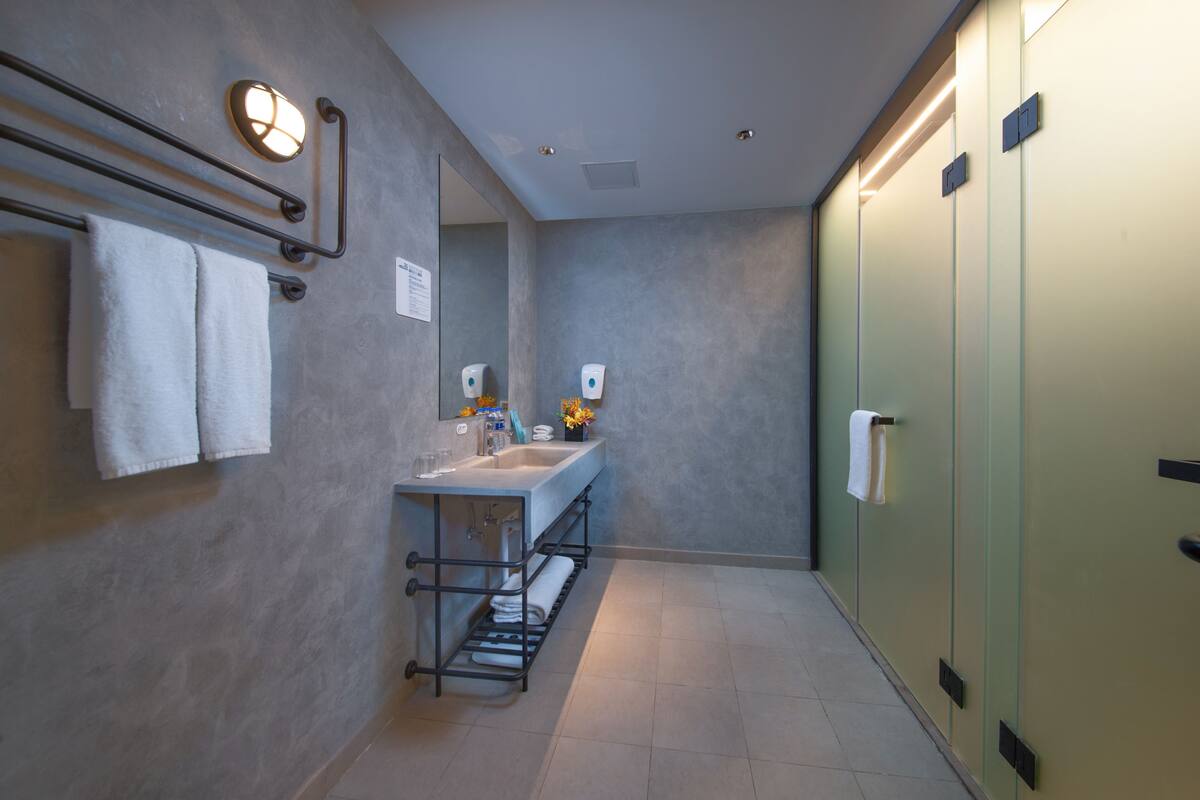 A modern bathroom with a sink, towel rack, and glass-enclosed shower.