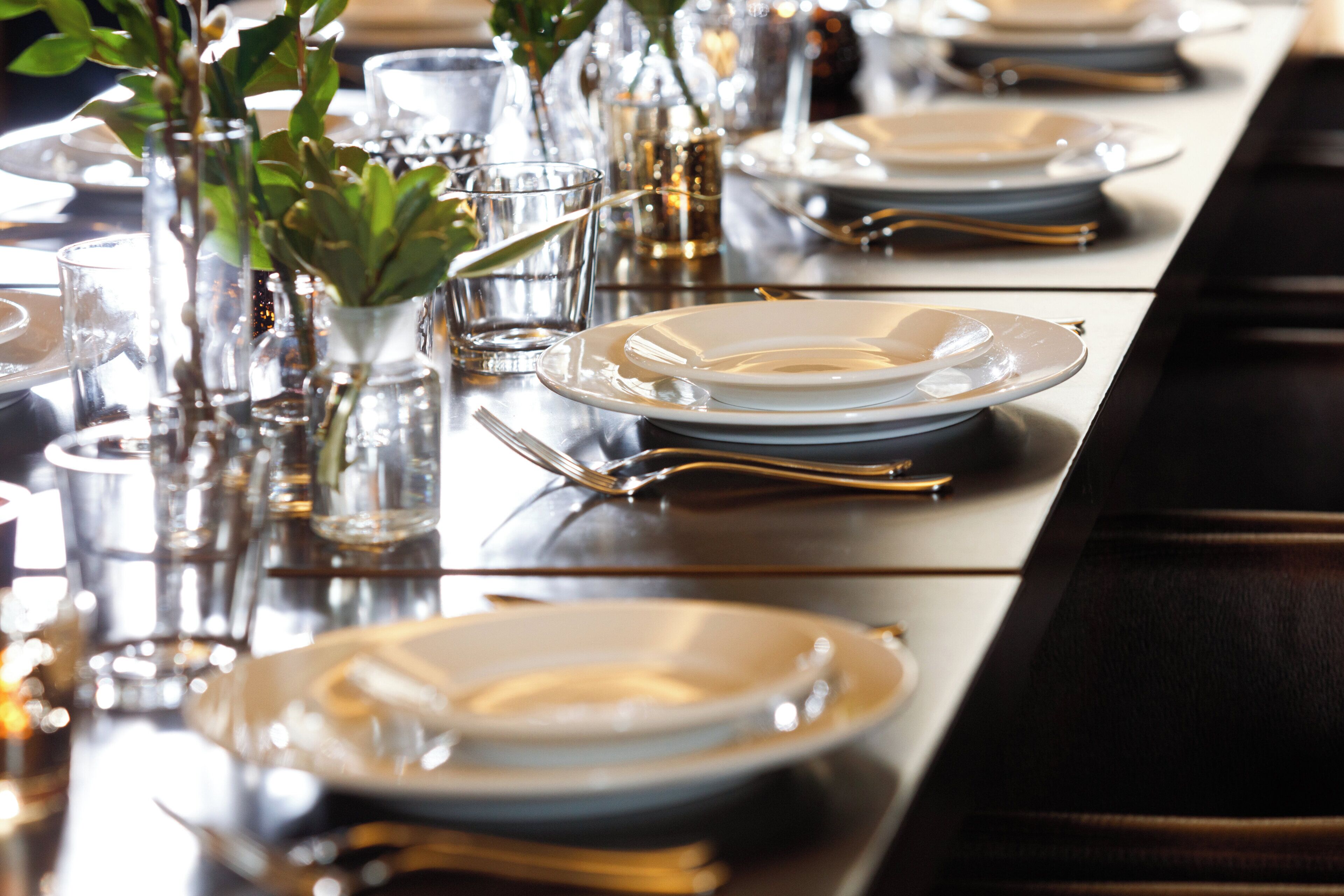 A table set with plates, glasses, and cutlery, suggesting a formal dining arrangement.