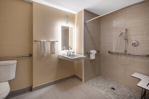 A modern bathroom with a shower, toilet, and sink.