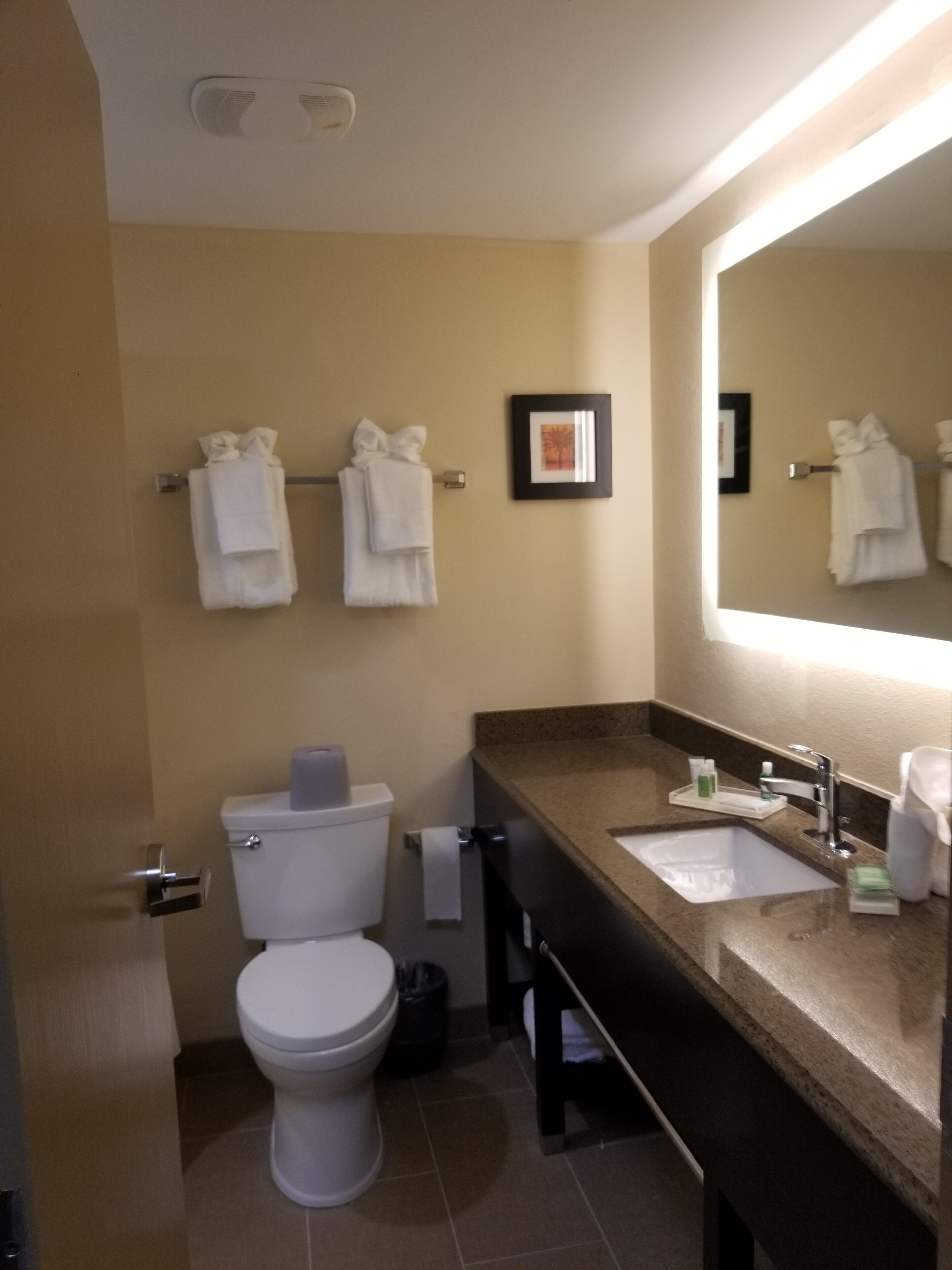 Un baño con inodoro, lavamanos y toallero.