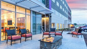An outdoor seating area with wicker chairs and a fire feature.