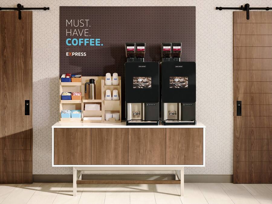 En kaffestation med två espressomaskiner, en kaffepress och olika sorters kaffekoppar och behållare.