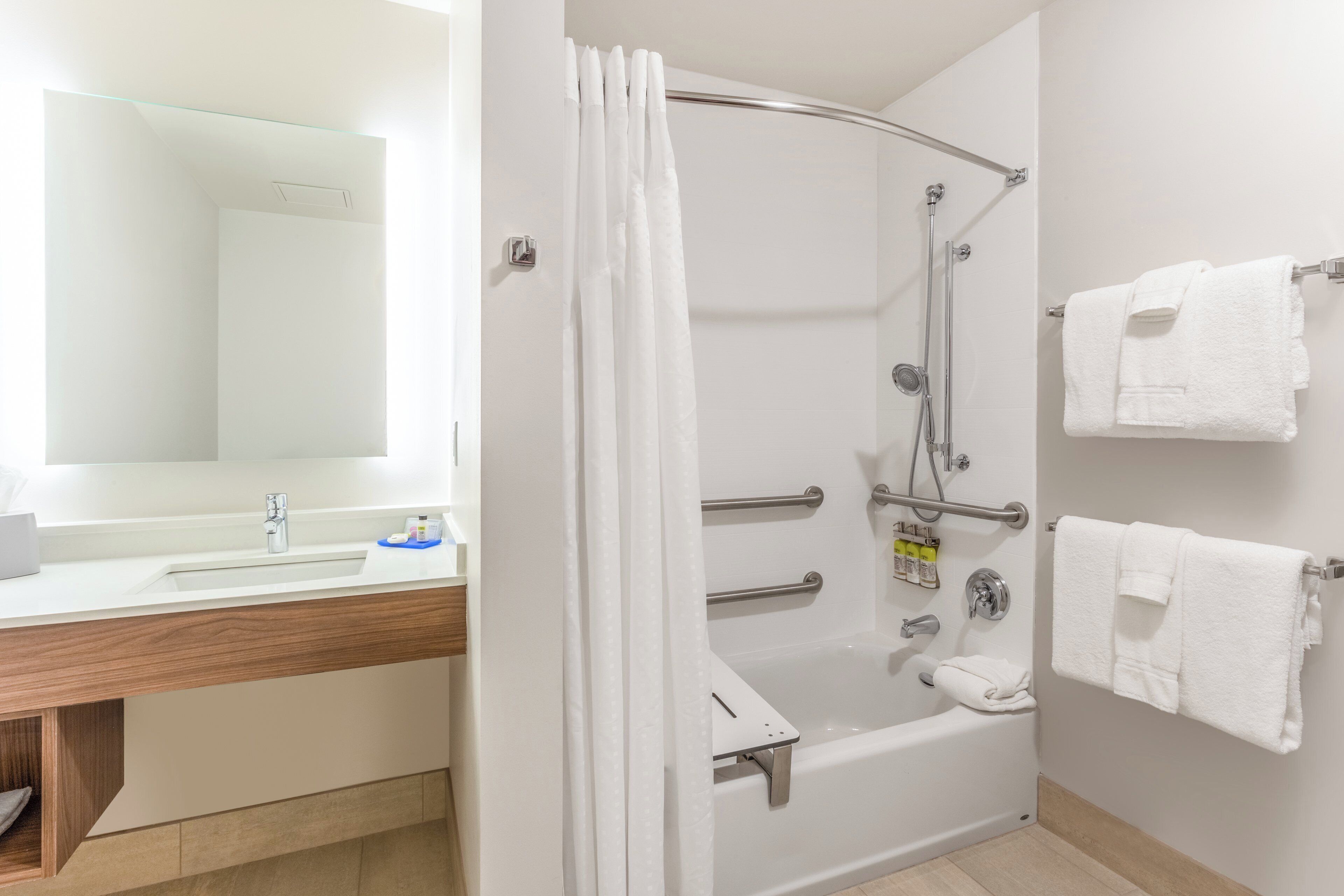 A modern bathroom with a shower, a sink, and a mirror.