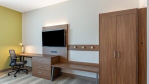 A modern office space with a wooden desk, a mounted TV, and a large wardrobe. - Holiday Inn Express & Suites Springfield North by IHG (Springfield)