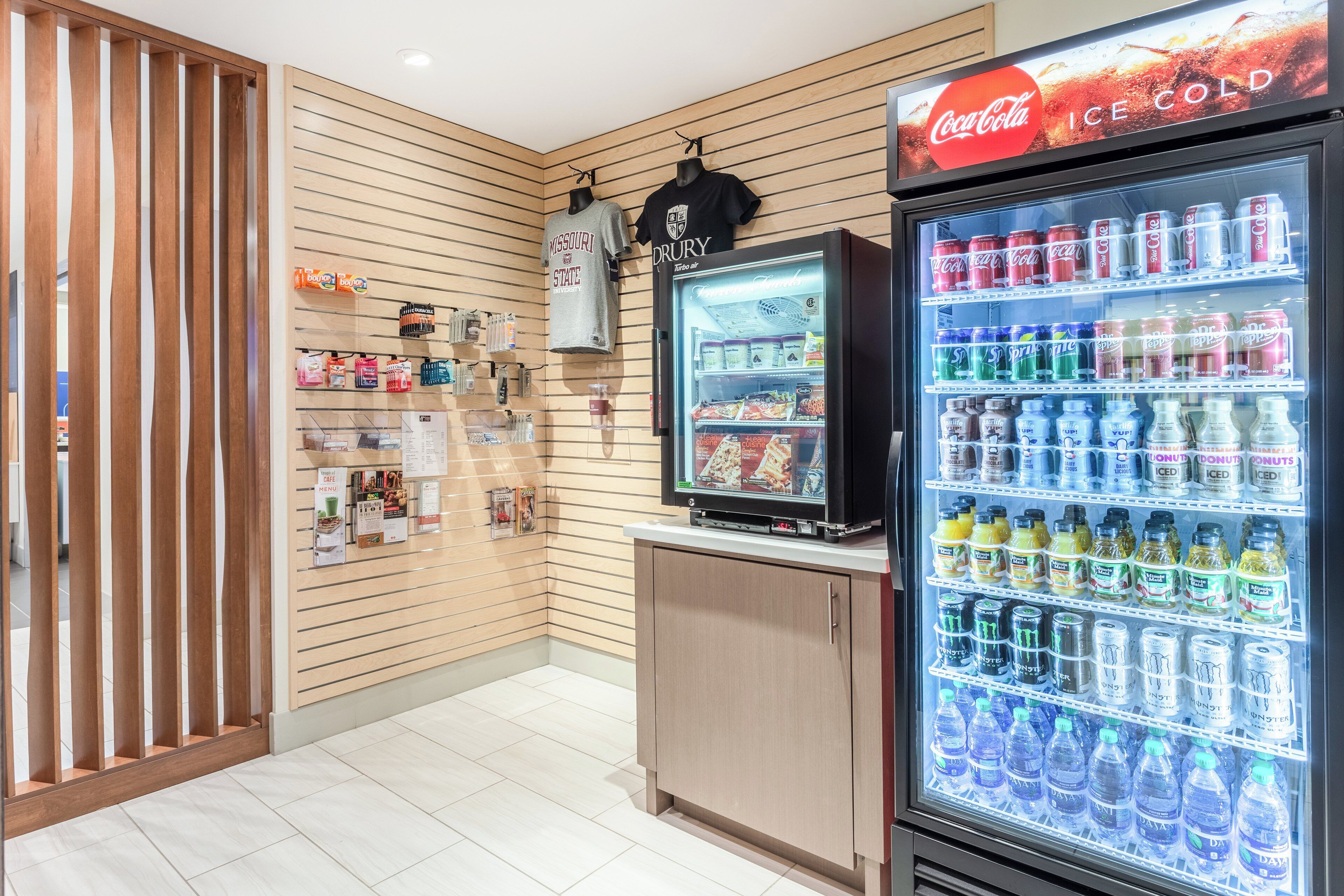 A vending machine stocked with beverages and a display of snacks.