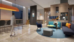 Un interior moderno con mostrador de recepción, zona de estar y cocina.