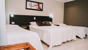 A hotel room with two single beds, a wooden bench, a framed picture on the wall, and a tiled floor. - Altos del Iguazu Hotel (Puerto Iguazú)