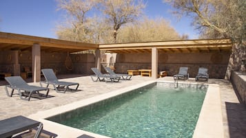 Alberca al aire libre, sombrillas en la alberca y camastros