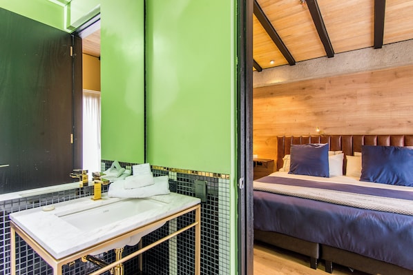 A bathroom with a white sink, green walls, and a wooden ceiling.