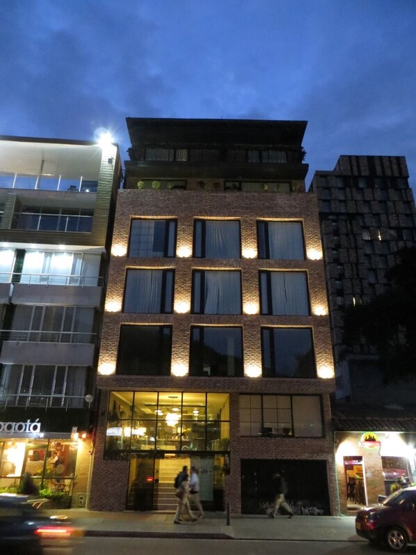 A multi-story building with a brick facade, large windows, and a ground-level entrance.