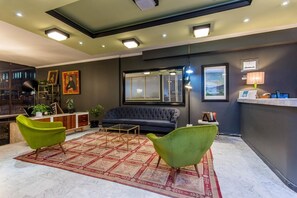 Un salon moderne avec un canapé, deux fauteuils, une table basse et un tapis à motifs.