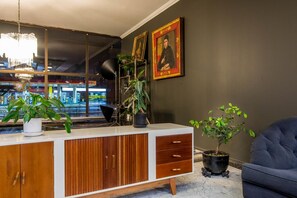 A modern living room with a white and wood-toned cabinet, a blue sofa, and a potted plant.