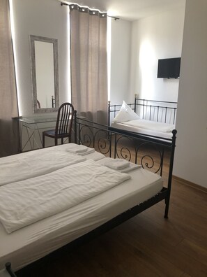 Habitación triple | Escritorio, tabla de planchar con plancha, wifi gratis y ropa de cama