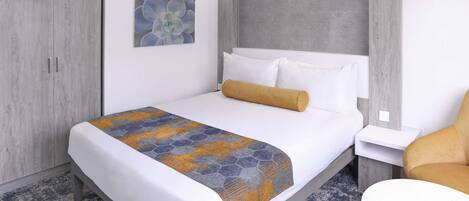 A hotel room with a bed, a nightstand, a chair, and a wardrobe.