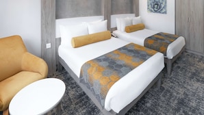 Une chambre d’hôtel avec deux lits, un canapé, une petite table et une armoire.