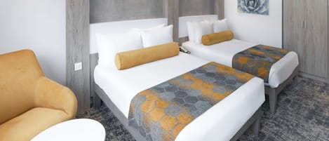 A hotel room with two beds, a sofa, a small table, and a wardrobe.