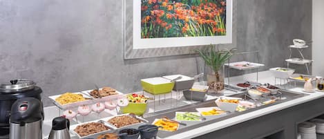 A buffet setup with various food items and serving utensils.