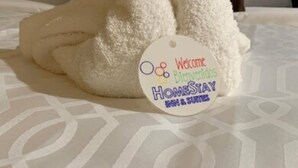 A bed with a white blanket and a tag on it. - HomeStay Inn & Suites Edinburg (Edinburg)