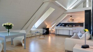 A modern loft apartment with a dining area, a kitchen, and a living space. - Design Hotel Zur Abtei (Aachen)