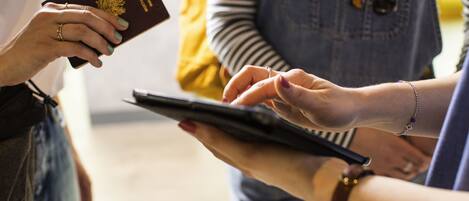 A person holding a passport and a tablet.