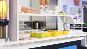 A breakfast bar with cereal, coffee, and condiments.