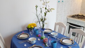 Ein Esstisch, gedeckt mit Tellern, Besteck und einer Blumenvase.