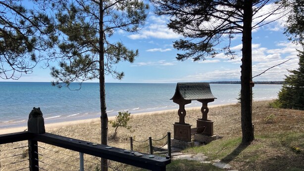 A wooden deck overlooking a beach with a small gazebo and a statue. - 8 Miles Of Sand Beach To Explore ~ Outstanding Sunrise Views Over The Lake! (Sturgeon Bay)