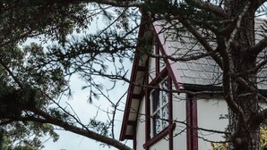 A house with a stone facade, a red roof, and a window with a black frame. -  Cottage by the lake (Raymond Island)