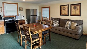A compact living space with a kitchenette, dining area, and a sofa.