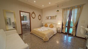 Ein Hotelzimmer mit Bett, Sitzgelegenheit, Badezimmer und Blick ins Freie.